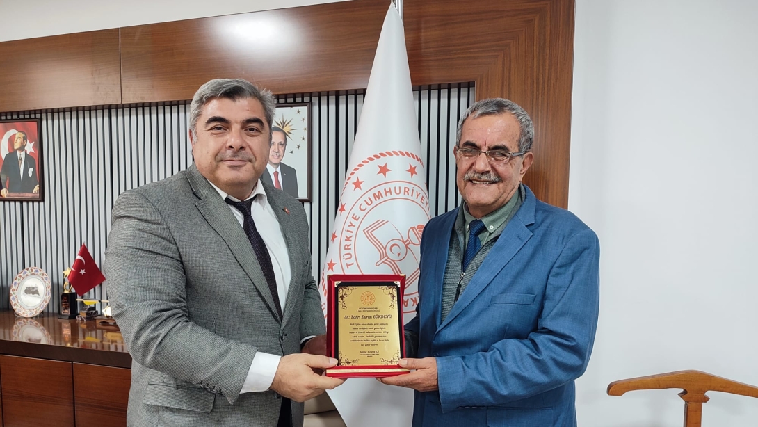 Müdür Sünnetci, Emekli Eğitim Müfettişi Gökdeniz’e Plaket Taktim Etti