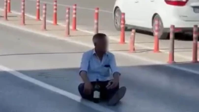 Trafiğin Ortasında Oturdu, Elinde Alkol Şişesiyle Tehlike Saçtı!